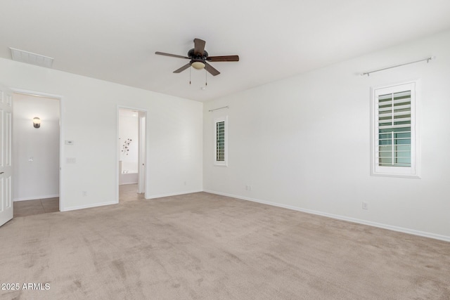 unfurnished bedroom featuring light colored carpet, baseboards, and ensuite bath