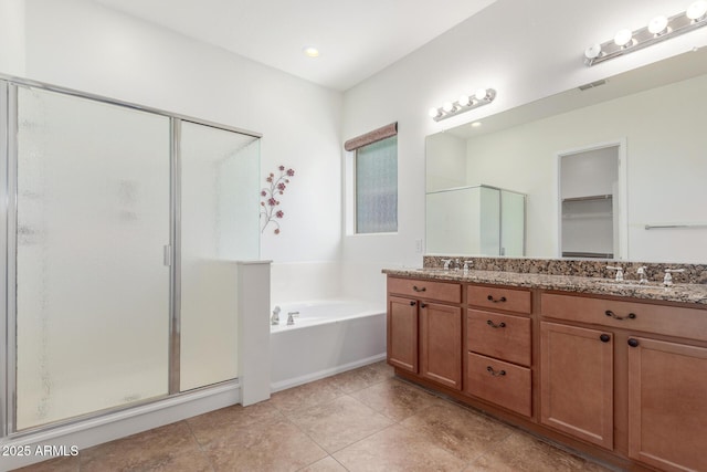 bathroom with a bath, a shower stall, double vanity, and tile patterned floors
