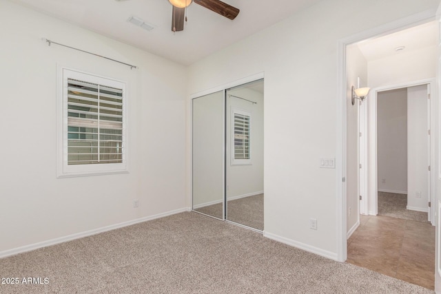 unfurnished bedroom featuring a closet, carpet, baseboards, and a ceiling fan