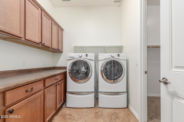 laundry area featuring washer and clothes dryer and cabinet space