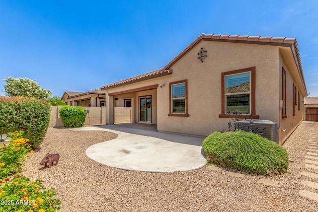 rear view of house featuring central AC, stucco siding, a patio, and a fenced backyard