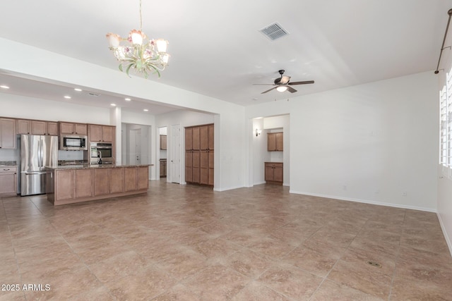unfurnished living room with a ceiling fan, a chandelier, recessed lighting, and baseboards