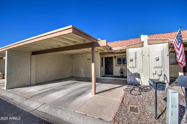 view of front of property featuring a tiled roof and an attached carport