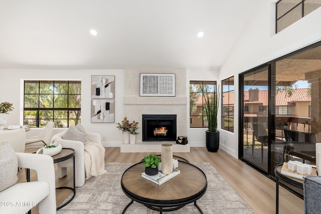 living room featuring recessed lighting, baseboards, light wood-type flooring, and a fireplace
