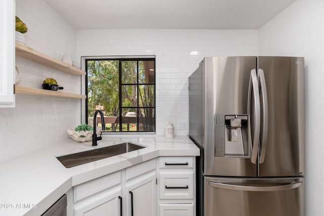kitchen featuring white cabinets, a sink, stainless steel fridge with ice dispenser, and tasteful backsplash