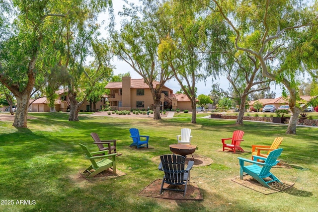 surrounding community with a lawn and an outdoor fire pit