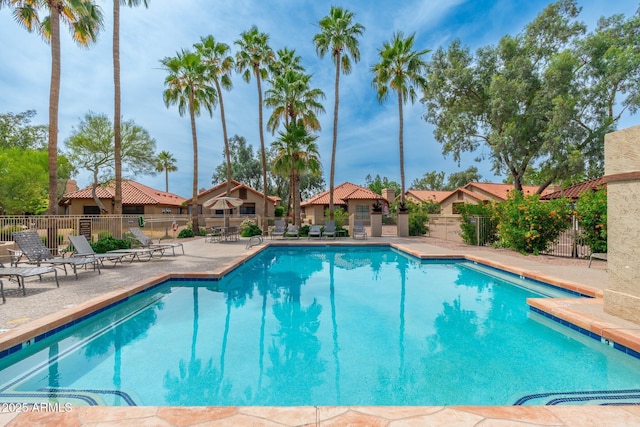 pool featuring fence and a patio
