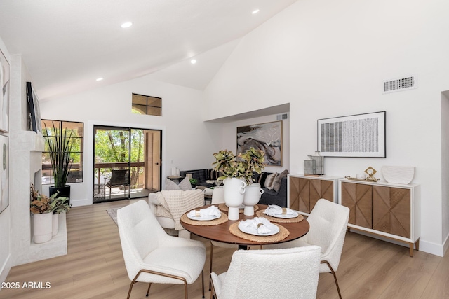 dining area with recessed lighting, high vaulted ceiling, visible vents, and light wood finished floors