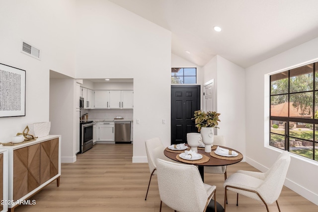 dining space featuring visible vents, baseboards, plenty of natural light, and light wood-type flooring