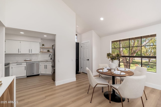 dining space featuring a healthy amount of sunlight, baseboards, recessed lighting, and light wood finished floors