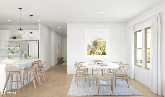 dining space with sink and light hardwood / wood-style floors