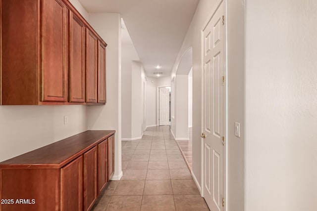hallway featuring baseboards and light tile patterned floors