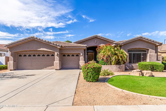 view of front of property with a tile roof, a front lawn, a garage, stucco siding, and concrete driveway