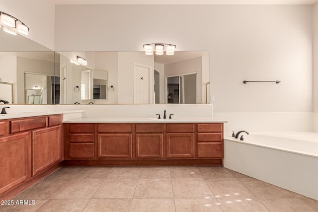bathroom with tile patterned floors, vanity, and a garden tub