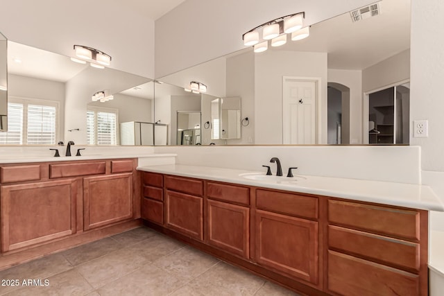 bathroom with double vanity, visible vents, a sink, and tile patterned flooring