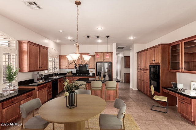 kitchen featuring dark countertops, light tile patterned floors, visible vents, pendant lighting, and black appliances