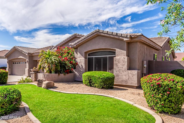 view of front of home featuring a tile roof, an attached garage, a front lawn, and stucco siding
