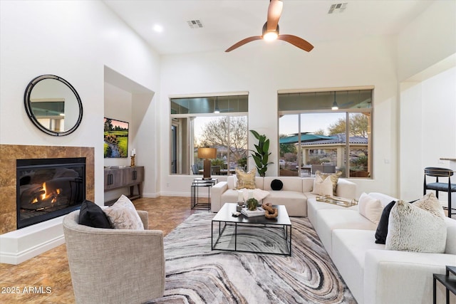 living room with a fireplace and ceiling fan