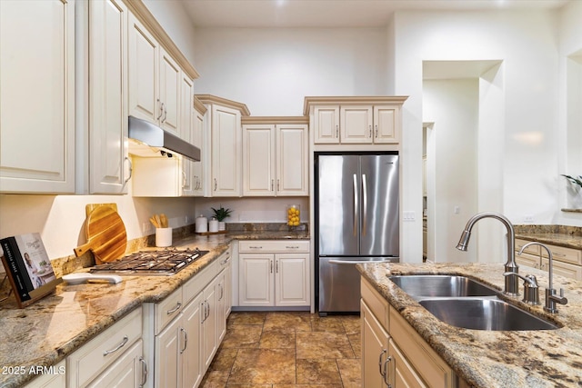 kitchen featuring light stone counters, sink, and stainless steel appliances