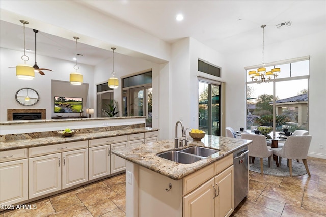 kitchen featuring light stone counters, an inviting chandelier, sink, and hanging light fixtures