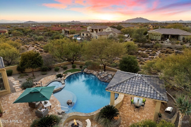 pool at dusk featuring a gazebo, a mountain view, and a patio area