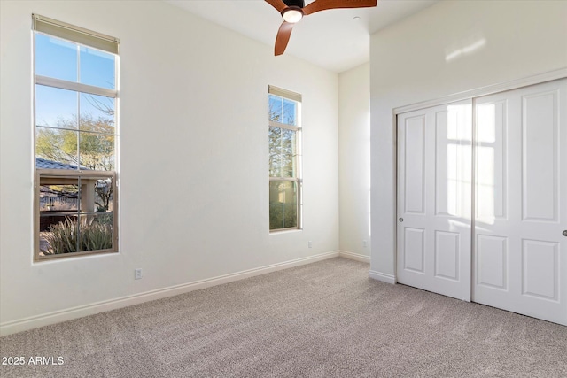 unfurnished bedroom featuring light carpet, ceiling fan, and a closet