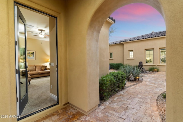 exterior entry at dusk featuring a patio