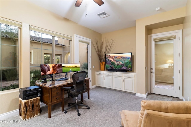 carpeted home office featuring ceiling fan