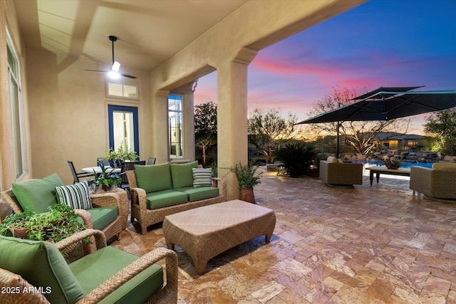 patio terrace at dusk with outdoor lounge area and ceiling fan