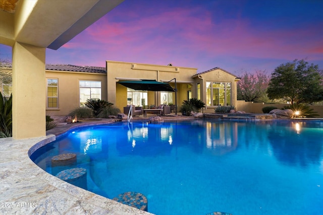 pool at dusk featuring a patio area