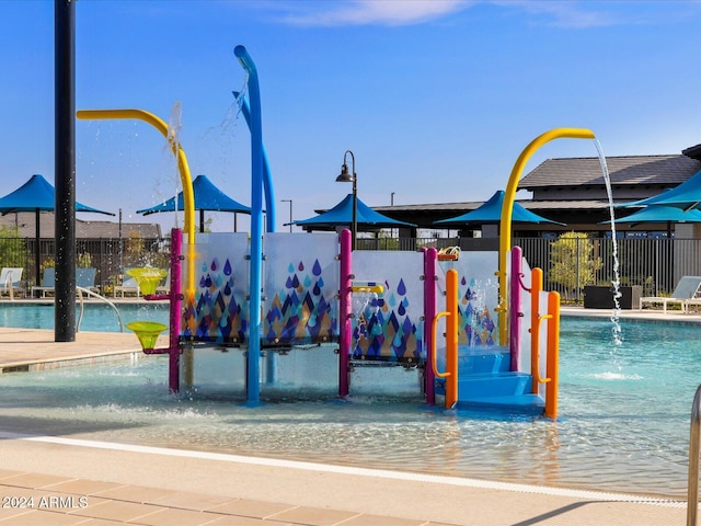 view of playground with pool water feature and a community pool