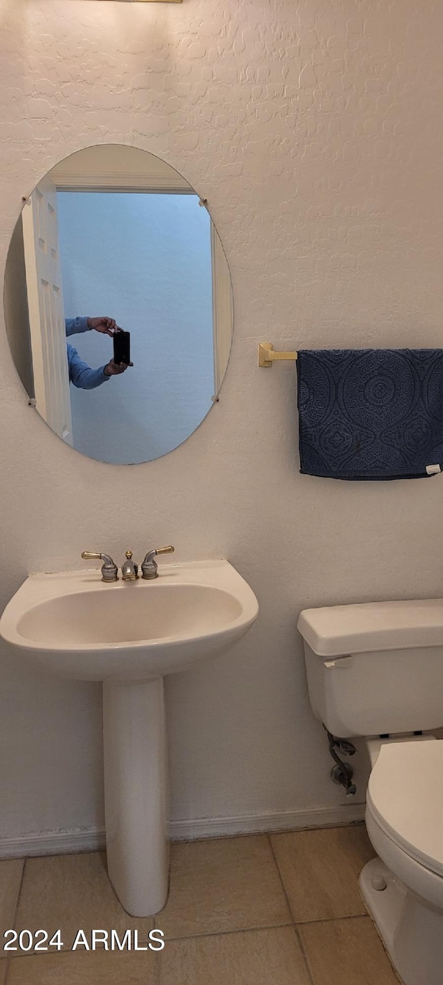 bathroom featuring tile patterned flooring, toilet, and sink