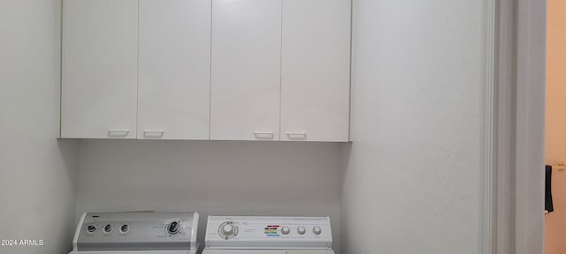 washroom with washer and clothes dryer and cabinets