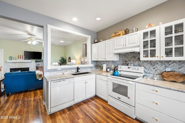 kitchen with a sink, tasteful backsplash, glass insert cabinets, white appliances, and ceiling fan