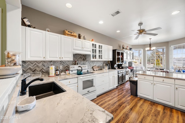 kitchen featuring electric range, a sink, white cabinetry, and ceiling fan