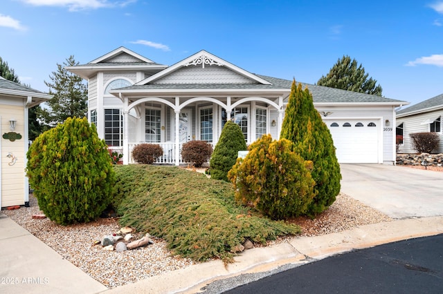 view of front of property with concrete driveway, roof with shingles, and an attached garage