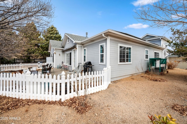 view of side of home with fence and a patio area