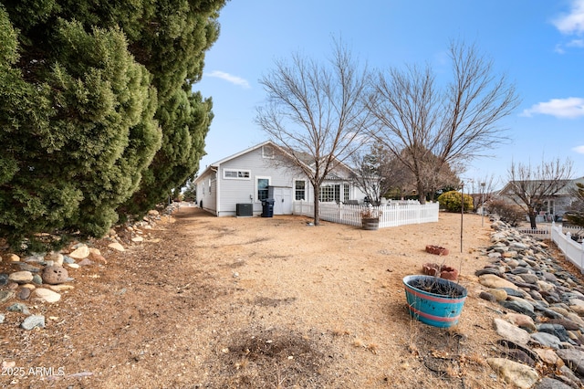 view of yard with central AC unit and fence