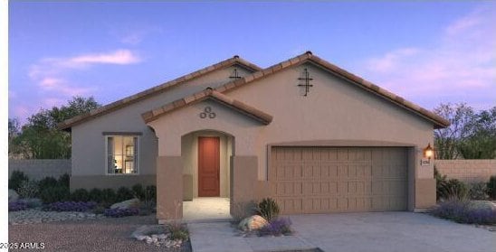 mediterranean / spanish home featuring a garage, stucco siding, and concrete driveway