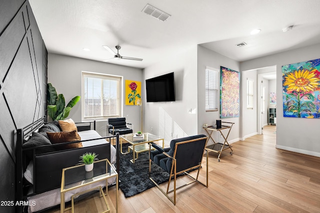 living room with ceiling fan and light wood-type flooring