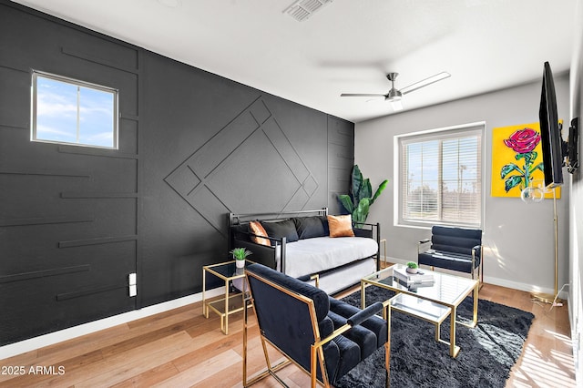 living area with ceiling fan and wood-type flooring