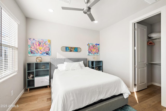 bedroom with ceiling fan, light hardwood / wood-style floors, and a closet