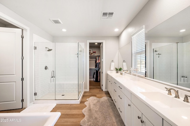 bathroom with vanity, wood-type flooring, and walk in shower