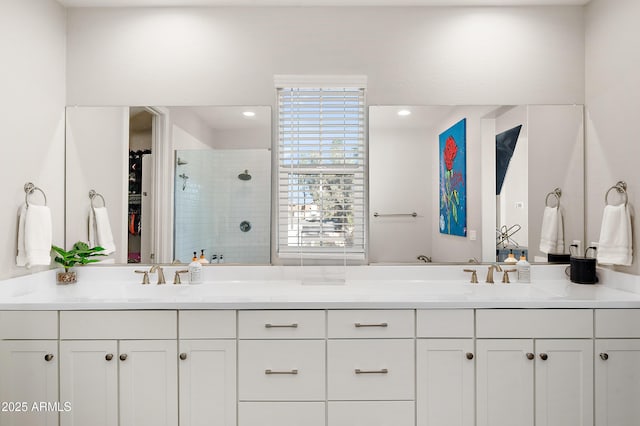 bathroom with a tile shower and vanity