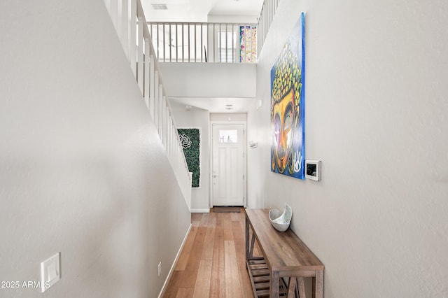 interior space with wood-type flooring and a towering ceiling