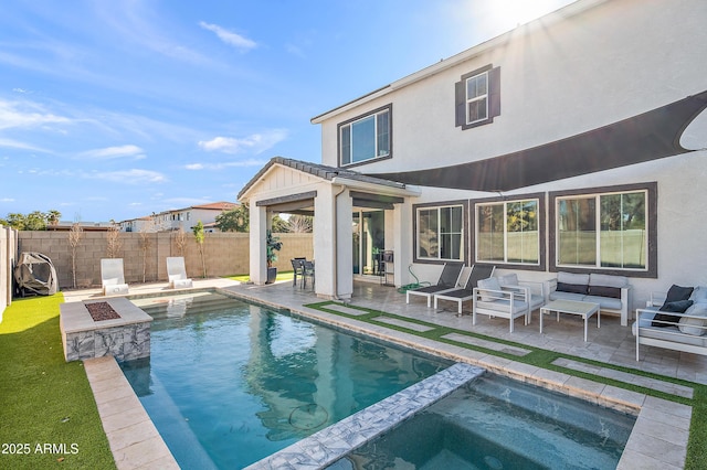 rear view of property featuring a pool with hot tub, an outdoor living space with a fire pit, and a patio