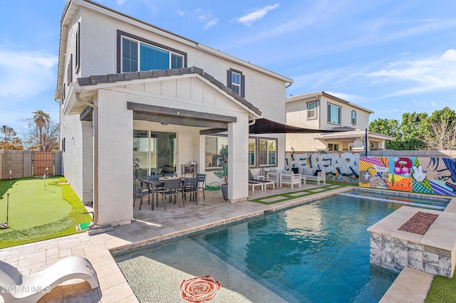 rear view of property featuring a patio area and a fenced in pool