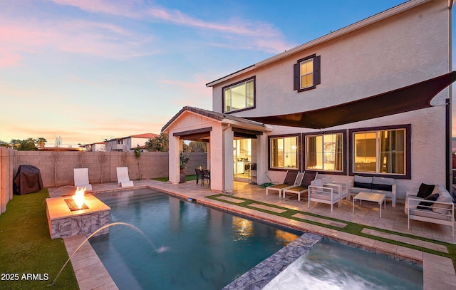 pool at dusk featuring an outdoor fire pit and a patio area