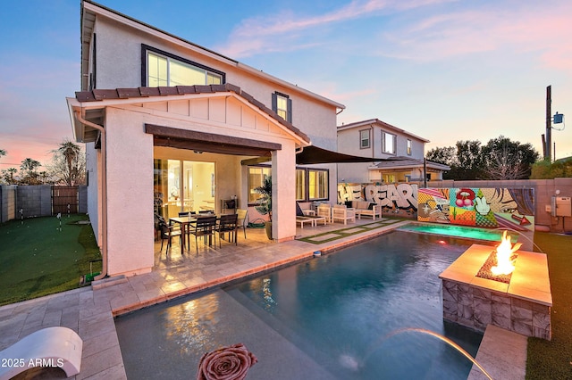 pool at dusk featuring a patio area and a fire pit