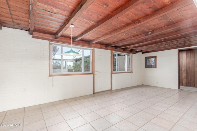 empty room with light tile patterned floors, brick wall, beamed ceiling, and wood ceiling